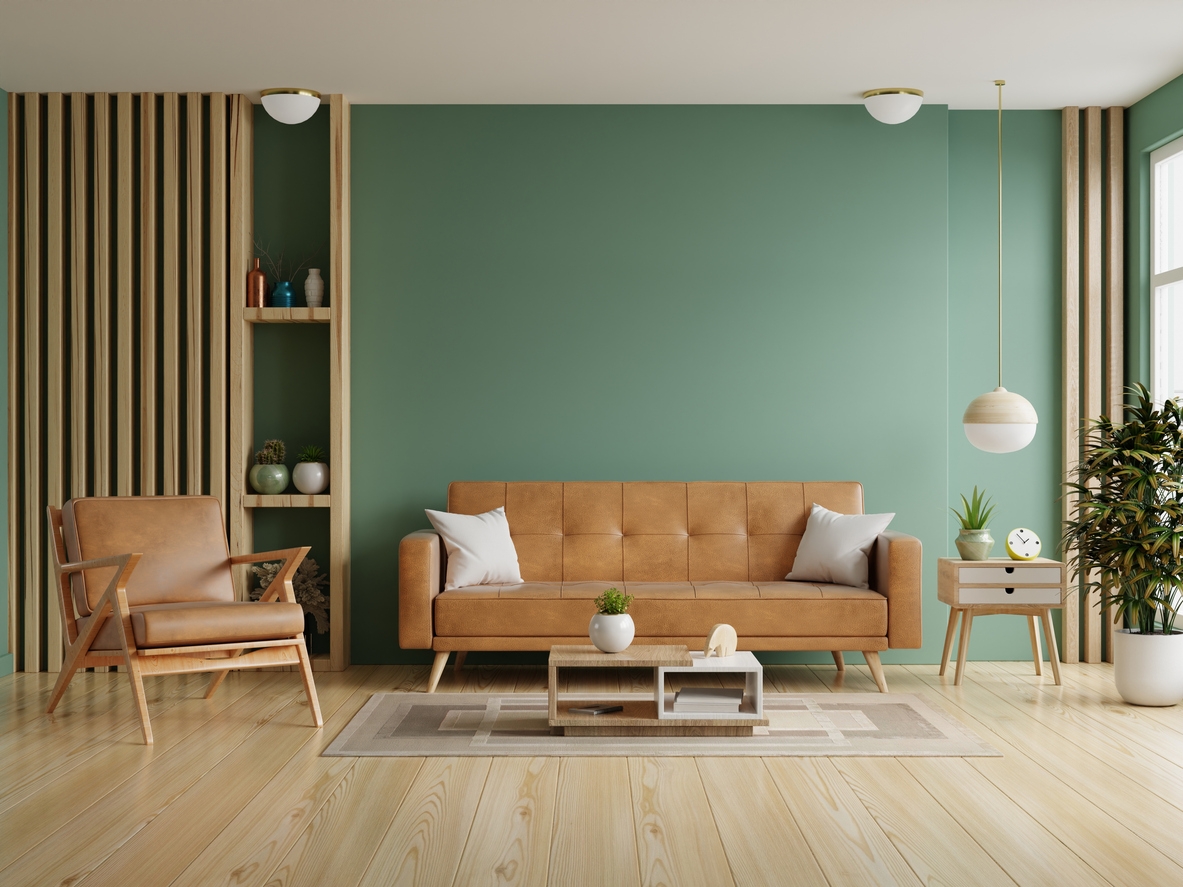 Living room with leather sofa and leather armchair on empty dark green wall in a San Ramon, CA home.