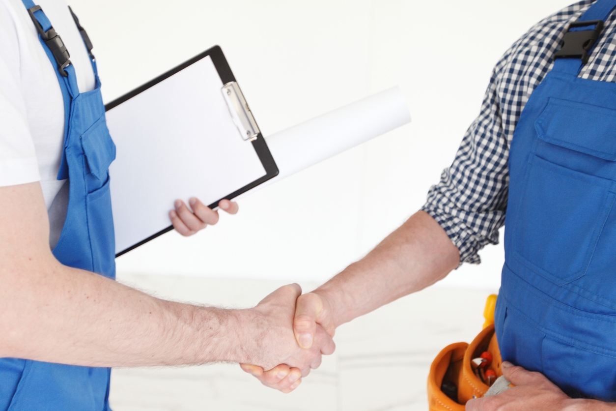 Two construction workers shaking hands